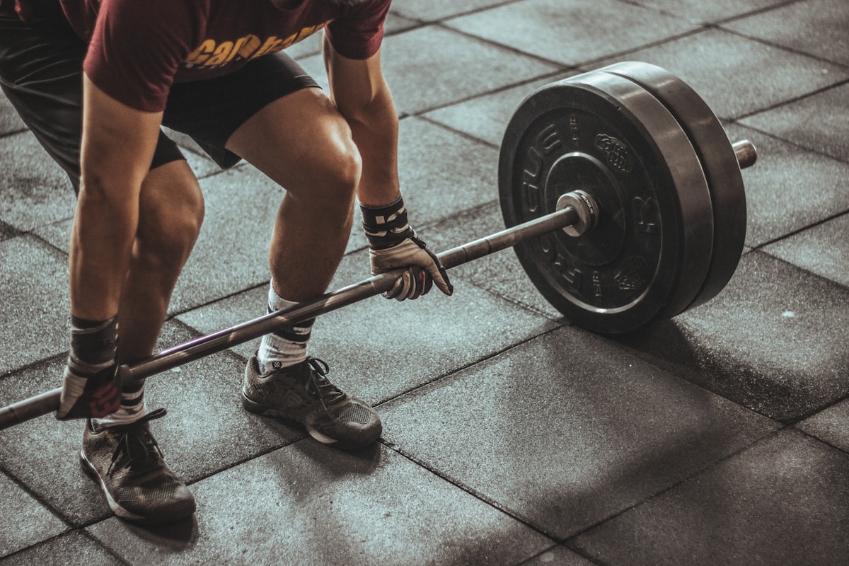 Pria sedang berolahraga dengan dumbbell di gym